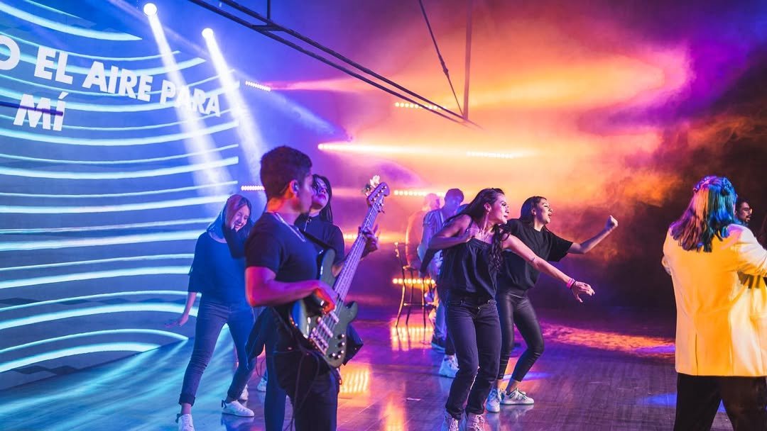 Músicos y cantantes de Soplo de Vida bajo luces de colores