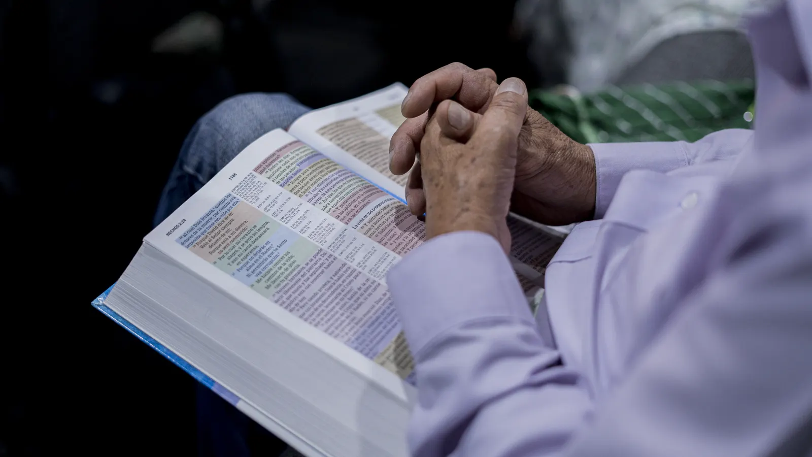 Una persona ora con una Biblia abierta